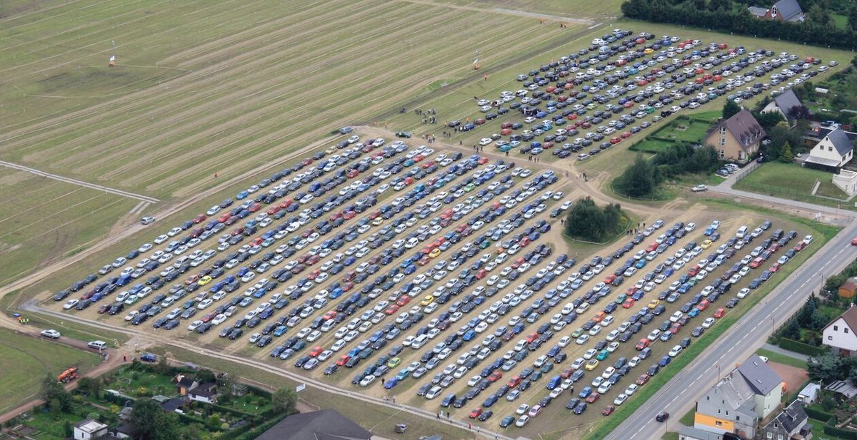 Luftaufnahme eines Veranstaltungsparkplatzes mit hunderten geordnet parkenden Autos