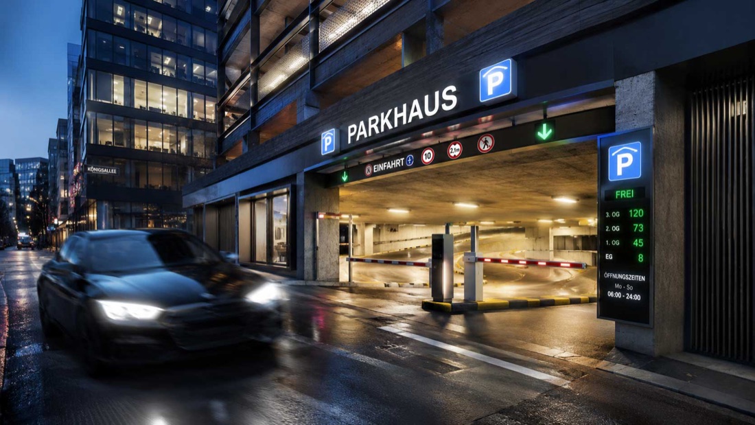 Beleuchtete Parkhaus-Einfahrt mit digitaler Belegungsanzeige am Abend